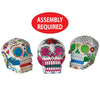 Three colorful skull-shaped toys with assembly required text on a white background