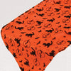 Orange fabric with black Halloween patterns on a white background