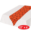 Orange table runner with black cat pattern on a white background
