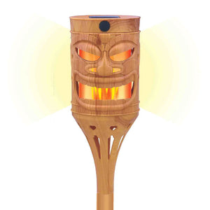 Wooden tiki torch with face design on a white background