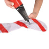 Hand using a red and black tool to puncture a white and red striped object on a white background