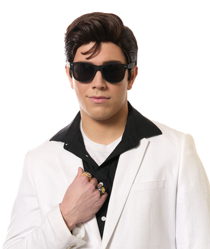 Person wearing a white suit, black shirt, and sunglasses on a white background