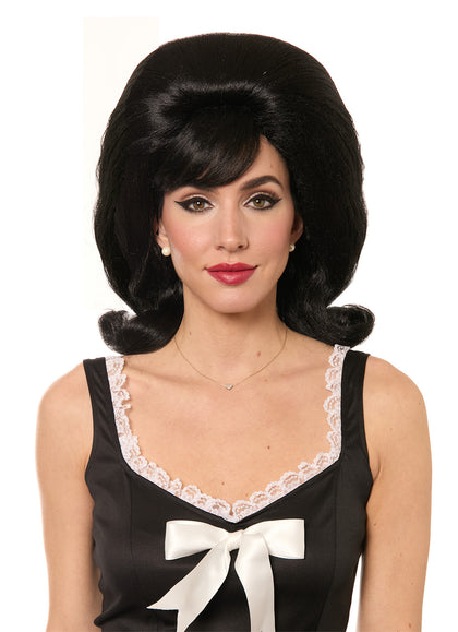 Woman wearing a black wig styled in a classic 1960s fashion with a white background.