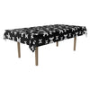 Table with a black tablecloth featuring white skull and crossbones pattern on a white background