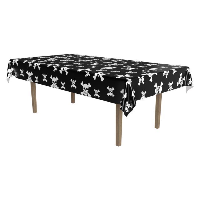 Black tablecloth with white skull and crossbones pattern on a wooden table.