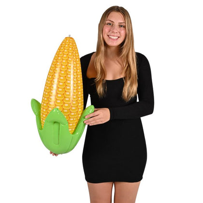 Woman holding a large inflatable corn toy against a white background