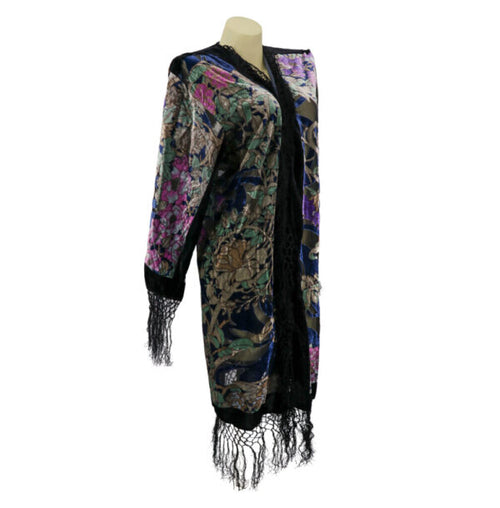 Floral patterned cardigan with black trim and fringes on a mannequin against a white background