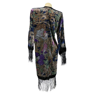 Colorful dress with intricate patterns and fringes on a mannequin against a white background