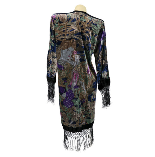 Colorful dress with intricate patterns and fringes on a mannequin against a white background
