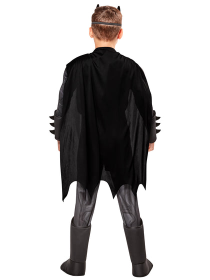 Child wearing a black superhero costume with cape and mask on a white background