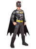 Child wearing a Batman costume with cape and mask on a white background