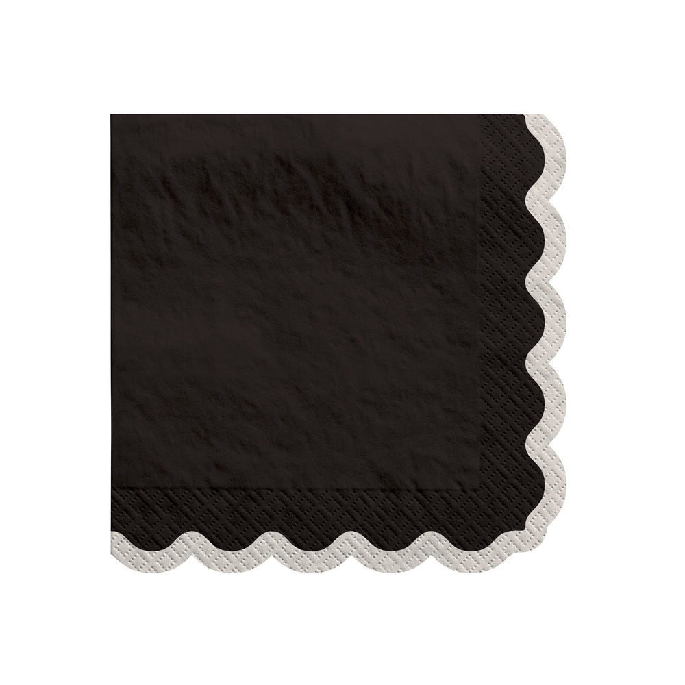 Black paper napkin with scalloped edge on a white background