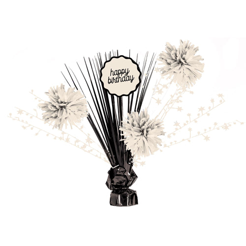 Decorative birthday centerpiece with black sticks, white flowers, and 'happy birthday' sign on a white background