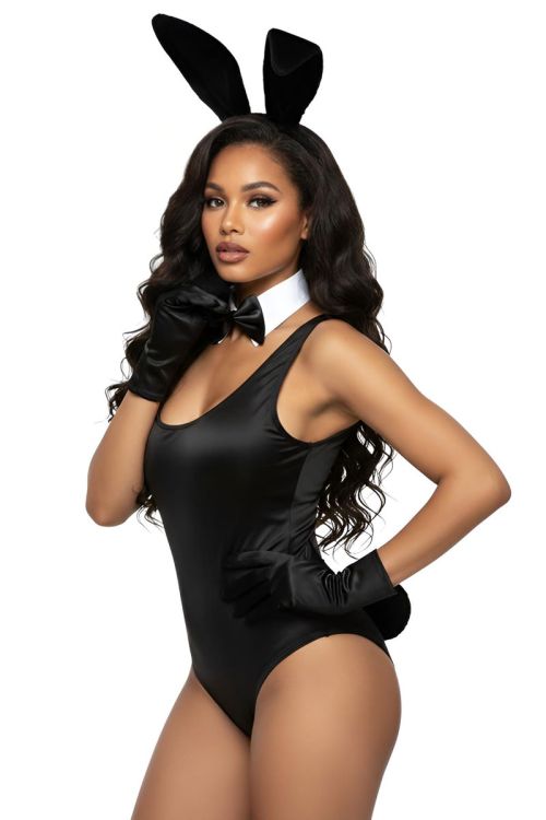 Woman wearing a black bunny costume with ears and bow tie on a white background