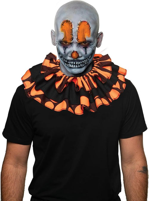 Person wearing a black shirt with an orange and black ruffled collar and a gray clown mask.
