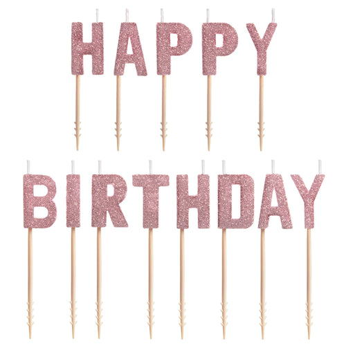 Rose gold glitter 'Happy Birthday' cake topper set on sticks against a white background