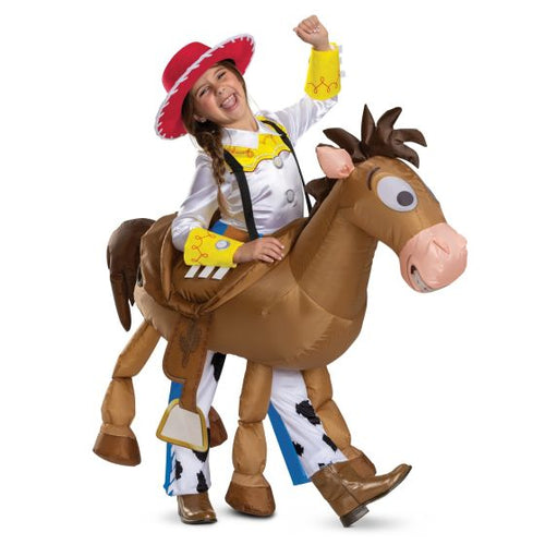 Child in a cowboy costume riding an inflatable horse on a white background