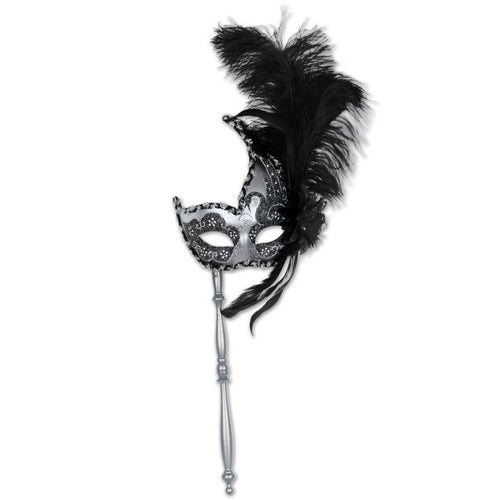 Black and silver mask on a stick with feathers against a white background
