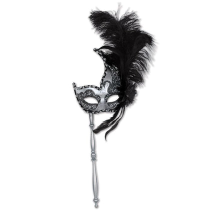 Black and silver mask on a stick with feathers against a white background