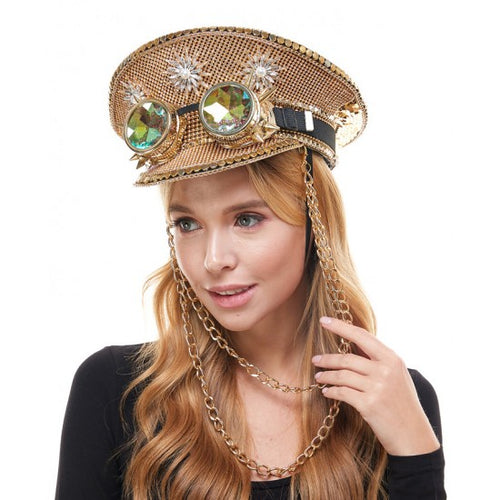 A woman wearing a steampunk-style gold hat with chain straps and large iridescent gem accents, photographed against a plain white background.