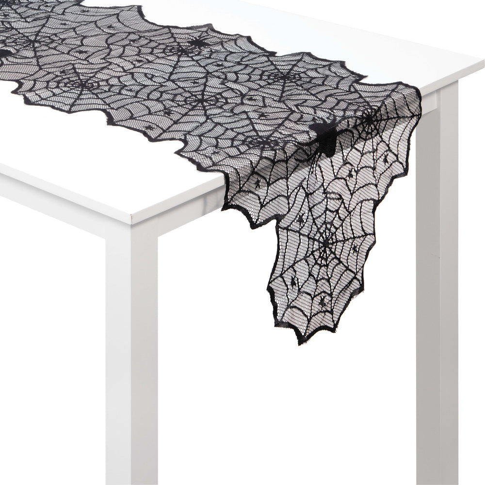 Black lace spider web table runner on a white table