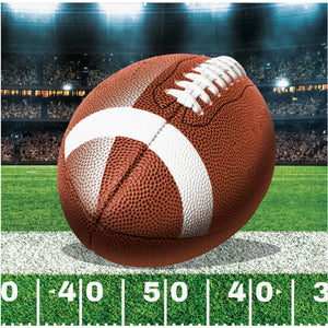 Football on a football field with stadium lights in the background