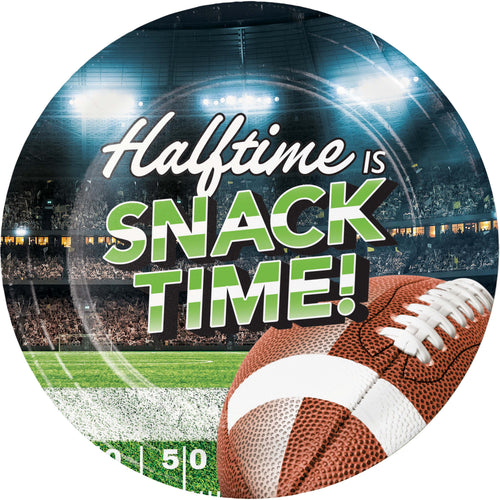 A round printed plate or sign featuring a football stadium scene with the text 'Halftime IS SNACK TIME!' and a football in the foreground.