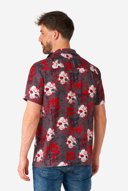 Man wearing a red and black patterned shirt with skulls on a white background