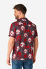 Man wearing a red and black patterned shirt with skulls on a white background