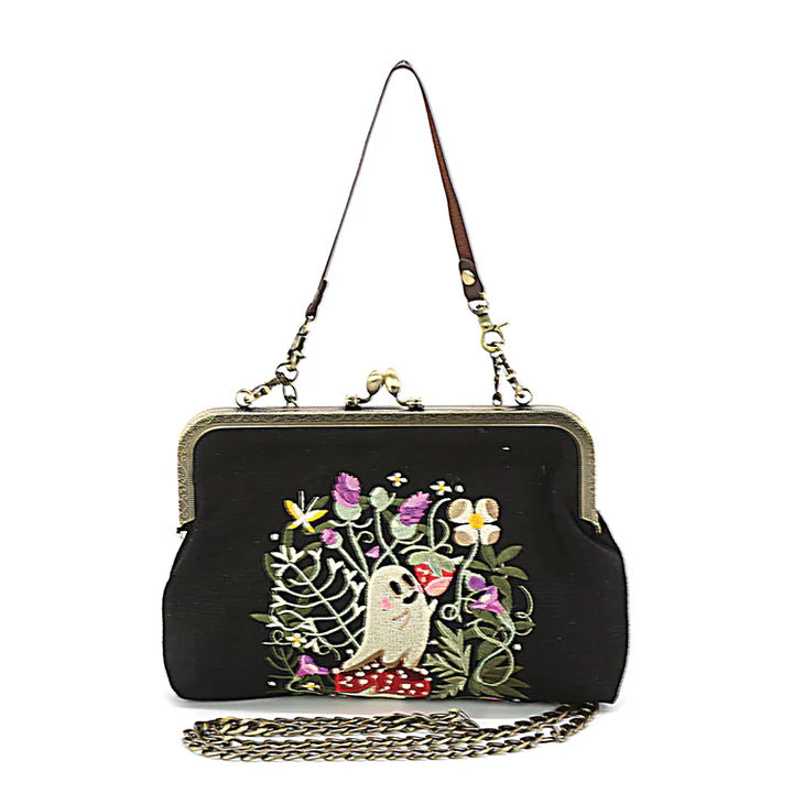 Black handbag with a owl and floral design on a white background