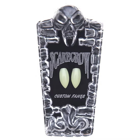 A coffin-shaped display card for 'Scarecrow' custom vampire fangs, featuring a skull and stone border design with two glowing pale green fangs in the center, on a white background.