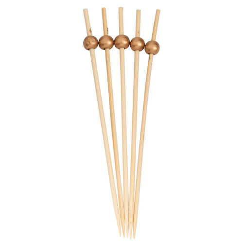Set of wooden skewers with gold beads on a white background