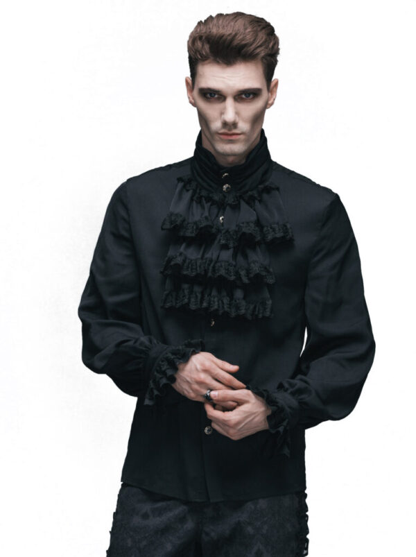 Man wearing a black gothic-style shirt with ruffled details on a white background