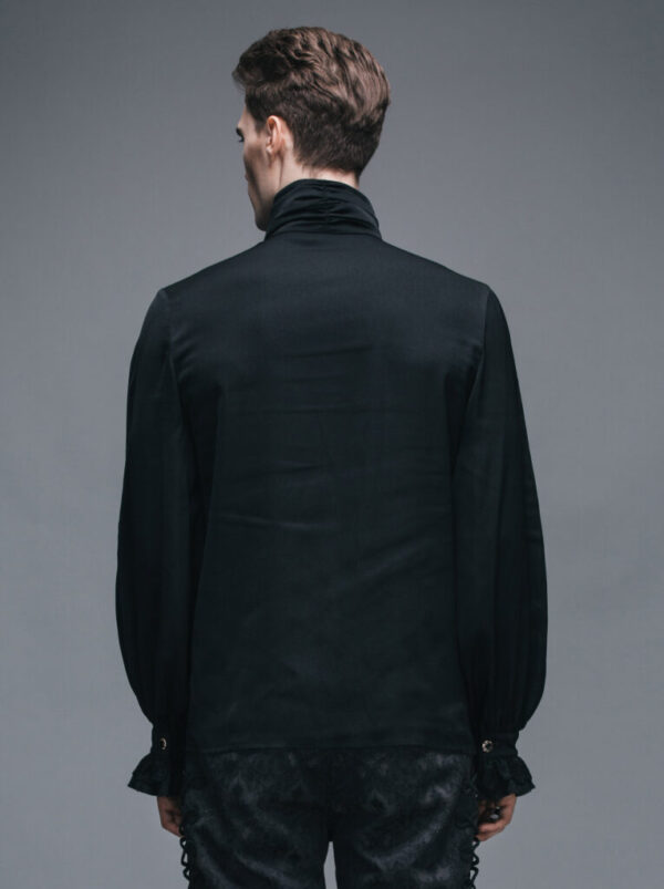 Man wearing a black shirt with ruffled cuffs and hem against a gray background