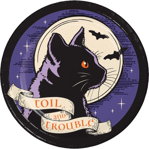A circular vintage-style illustration featuring a black cat in profile with one orange eye, set against a purple night sky with bats, stars, and a cream moon. A cream banner across the bottom reads 'TOIL and TROUBLE'.