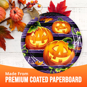 Halloween-themed paper plates with carved jack-o'-lantern illustrations on a purple background, styled with autumn leaves and pumpkins on a white wood surface, with an orange banner reading 'Made From PREMIUM COATED PAPERBOARD'.
