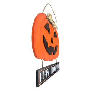 An orange jack-o'-lantern Halloween hanging decoration with a black carved face and a small rectangular sign below that reads “HAPPY HALLOWEEN,” suspended by twine on a white background.