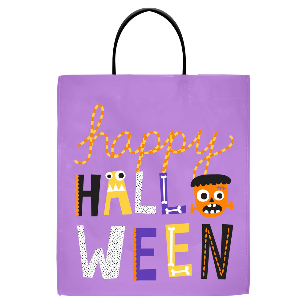 A purple Halloween gift bag with black handles, featuring a colorful 'Happy Halloween' text design with cartoon monster and ghost lettering on a white background.