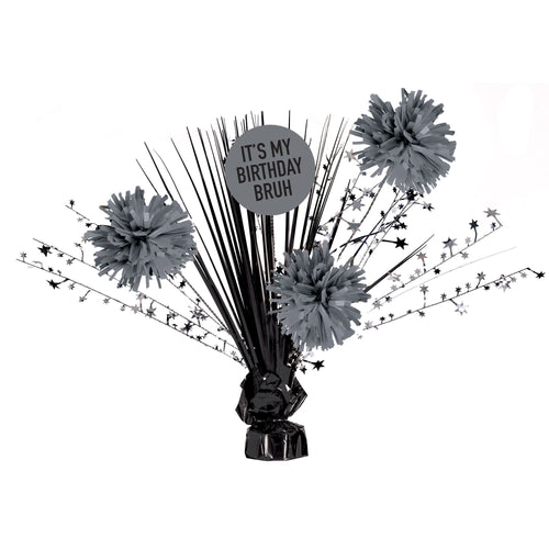 Decorative birthday centerpiece with gray pom-poms and a 'It's my birthday bruh' sign on a white background
