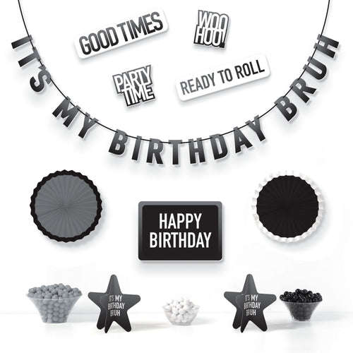 Black and white birthday party decorations with text and small items on a white background