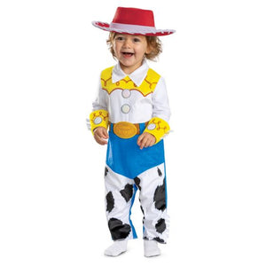 A toddler modeling a Woody-inspired costume from Toy Story, featuring a red and white cowboy hat, white shirt with yellow accents, blue pants, and black-and-white cow-print legs, against a plain white background.