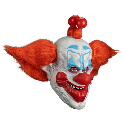Clown mask with red hair and white face with blue accents on a white background