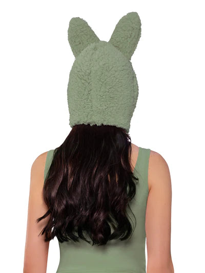 Person wearing a green knitted hat with bunny ears on a white background