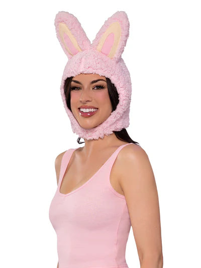 Woman wearing a pink fluffy bunny hat on a white background