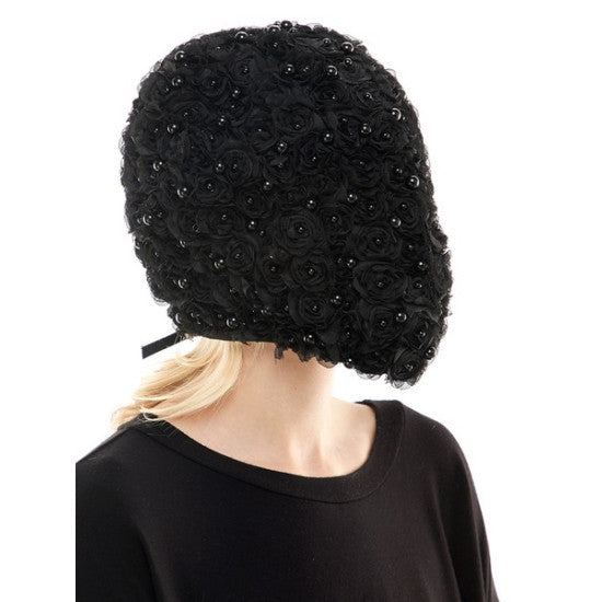 Black beaded headpiece worn by a person on a white background