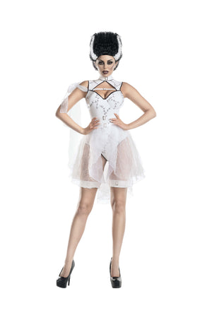 A woman modeling a white and black gothic costume dress with a sheer tulle skirt, black strappy harness-style bodice, and a black-and-white feathered hairpiece against a plain white background.