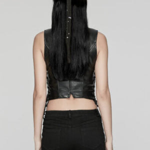 Person wearing a black leather top and ruffled black pants with a white background