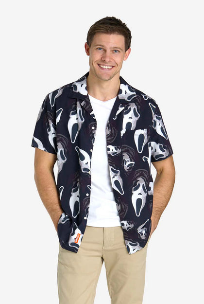 Man wearing a navy patterned shirt over a white t-shirt on a white background
