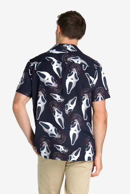 Person wearing a navy blue shirt with white ghost face pattern on a white background
