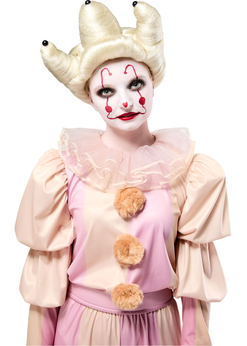Person in a clown costume with white makeup, red accents, and a horned headpiece on a white background